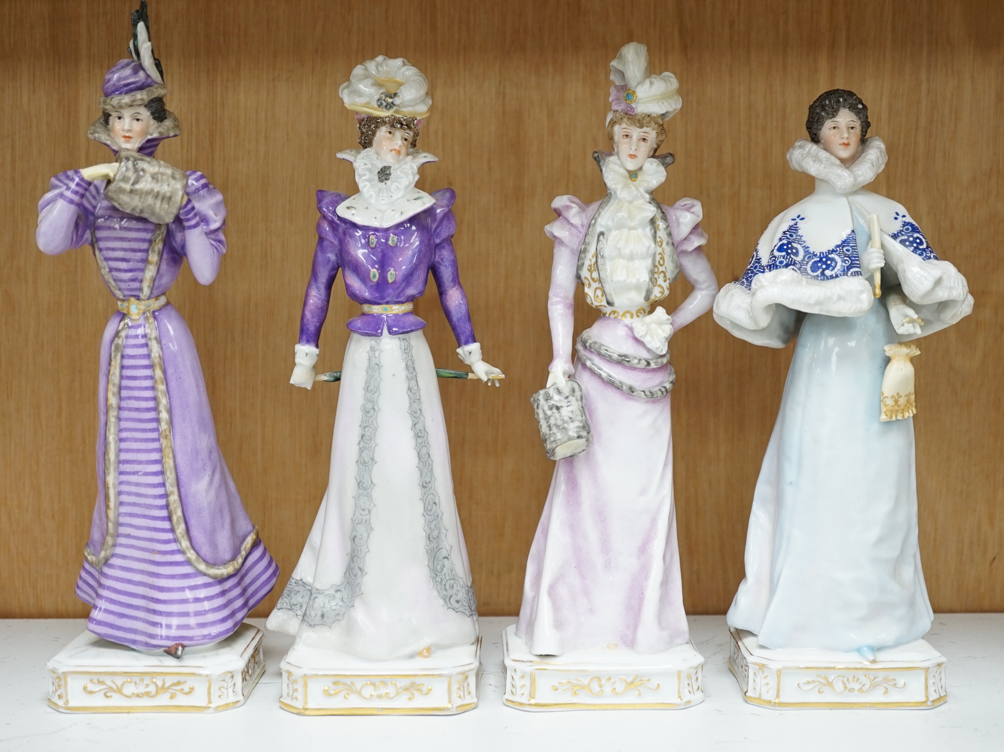 Four German Plaue porcelain figures of Edwardian fashionable ladies, tallest 27.5cm high. Condition - poor some chips